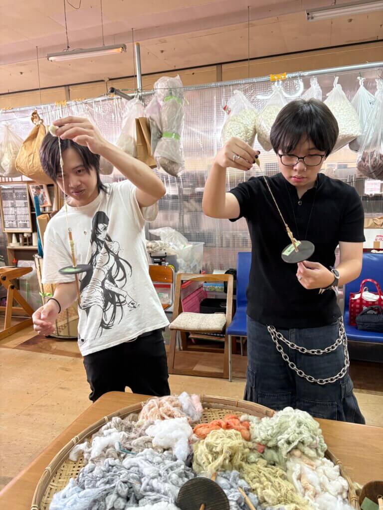 糸紡ぎ体験をしている様子